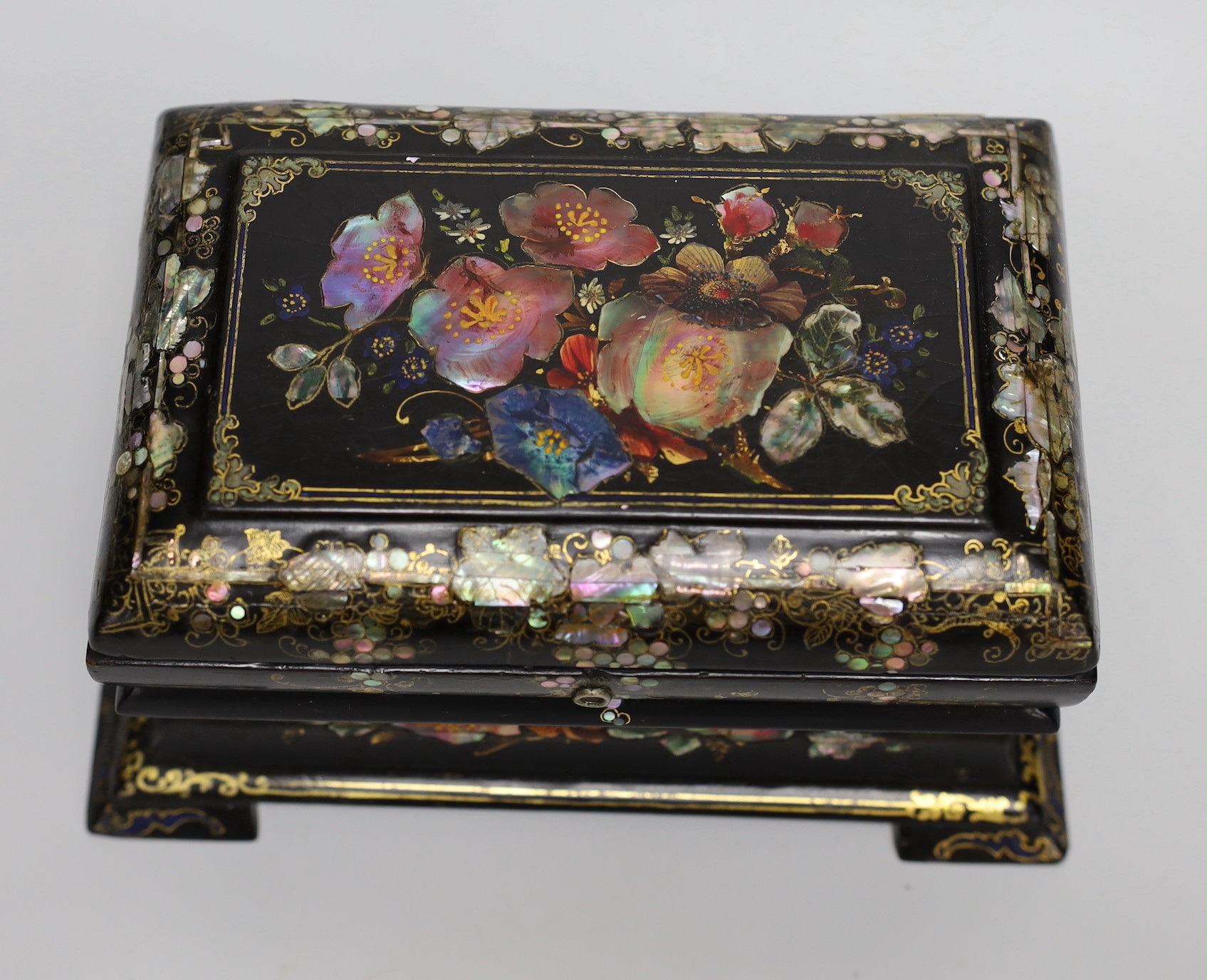 A Victorian painted and mother of pearl inlaid papier mache tea caddy. 23cm wide
